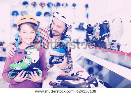 happy spanish father and son deciding on new roller-skates in sports store