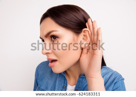 Close up portrait of brunette girl with cupped hand curiously listening to gossip or secret Royalty-Free Stock Photo #624183311