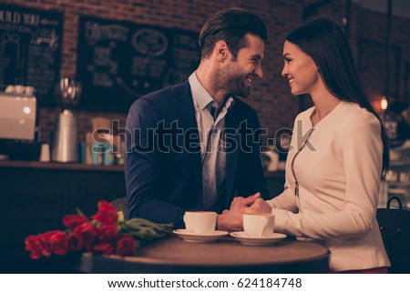 Happy romantic man and woman  sitting in a cafe with flowers drinking coffee Royalty-Free Stock Photo #624184748