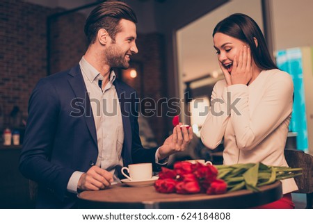 Making proposal in a cafe with ring and flowers Royalty-Free Stock Photo #624184808