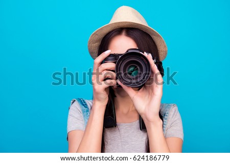 Close up photo of woman in hat on blue background taking a photo with digital camera Royalty-Free Stock Photo #624186779