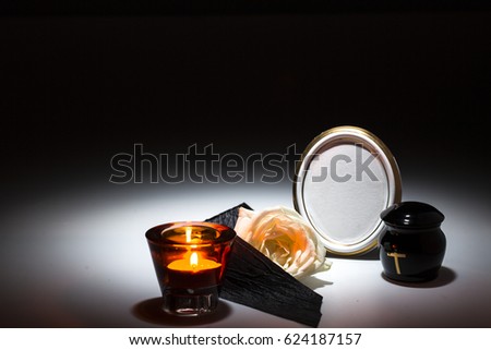 black urn with black tape,white rose, candle,for sympathy card on background
