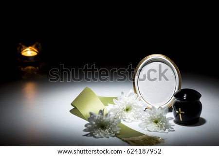 black urn with green tape,white chrysanthemum,candle for sympathy card on dark background