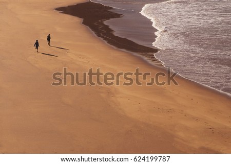 two kids running at beach - children playing at beach
