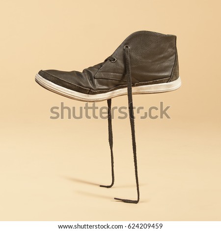 Green shoe standing in its laces. Concept photo manipulation. 