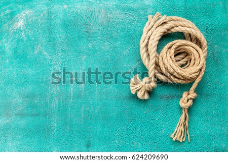 Ship rope knot on turquoise background. Top view. Place for text.