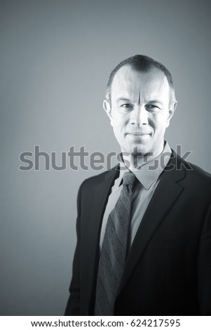 Businessman executive in suit, shirt and tie formal clothing aged in 40's against plain studio portrait background.