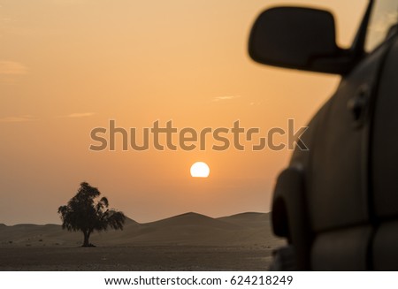 Silhouette of a car during the dawn of the desert
