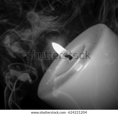 A black and white, close-up photograph of a burning candle with a smoke overlay. This photo was taken in Brisbane, Australia. 