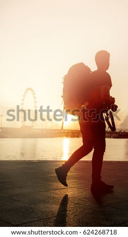 Silhouette traveler man holding DSLR camera for take a photo at the river