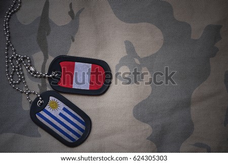 army blank, dog tag with flag of peru and uruguay on the khaki texture background. military concept