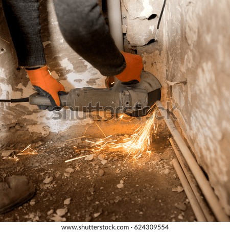 Worker cuts a metal pipe with sparks .