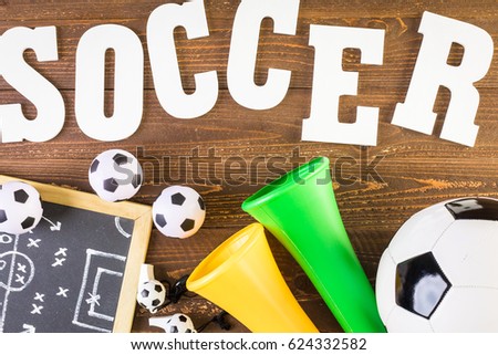 White letters Soccer vuvuzela stadium horns on a wood background.