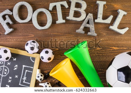 metal letters Football vuvuzela stadium horns on a wood background.