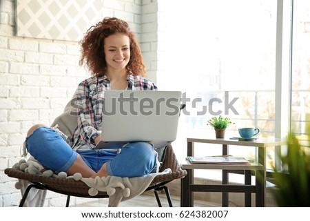 Beautiful young woman using laptop at home Royalty-Free Stock Photo #624382007