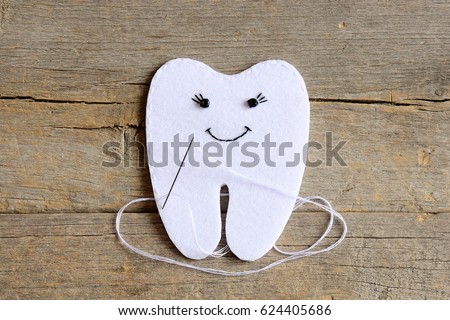 How to sew a felt tooth fairy. Step. Instruction for kids. Join the felt edges of felt tooth fairy with white thread. Vintage wooden background. Simple sewing projects and handmade crafts. Top view