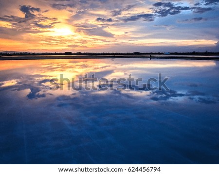 Sunset sky reflecting on a salt field. Ban Laem, Petchaburi, Thailand.
