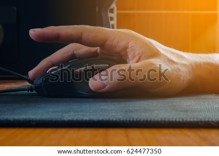 closeup of man hand clicking computer mouse and flare light side view