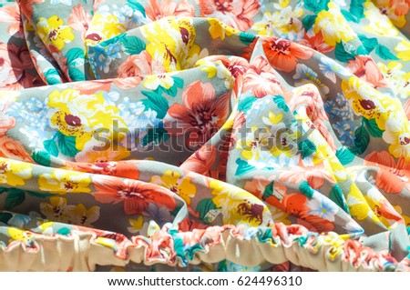 Texture, background, pattern. Girl's skirt. Silk fabric with floral pattern. Red Yellow Flowers