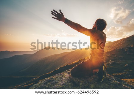 Man praying at sunset mountains raised hands Travel Lifestyle spiritual relaxation emotional concept vacations outdoor harmony with nature landscape Royalty-Free Stock Photo #624496592