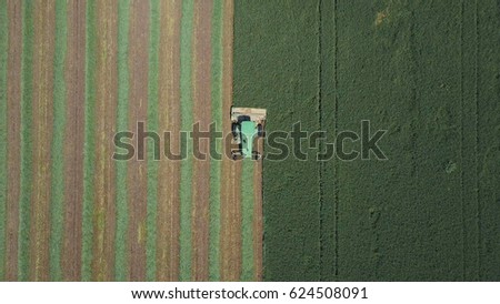 Combine harvester in a green field - Top down Aerial image