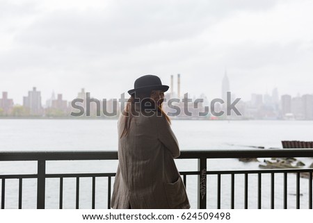 Asian Woman Standing in Brooklyn Looking at Manhattan on Rainy Day