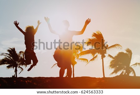 happy mother and son jumping having fun on sunset