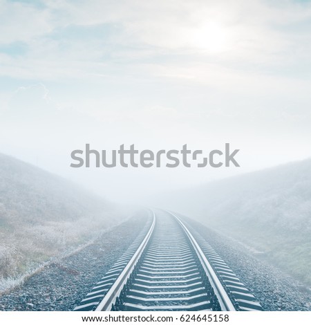 railroad in fog and sun in clouds