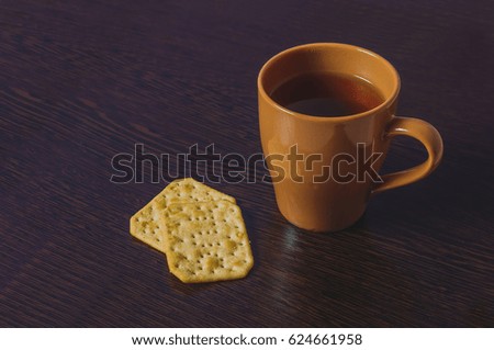 Cup of tea on wooden table with two cake
