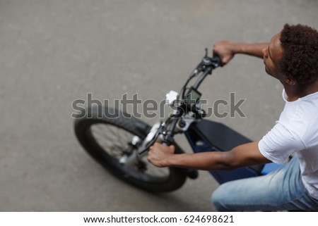 Top view of young man riding electric bike along the road, selective focus