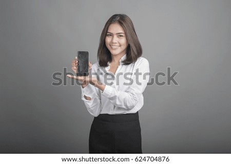 Beautiful Business Woman presenting smartphone on grey background