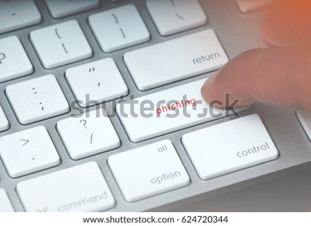 Cyber security concept. Finger pressed on the computer keyboard written PHISHING. Leak light and vintage editing.                               