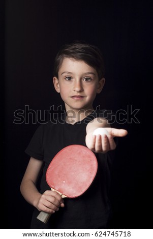 Low key portrait of young boy isolated on black background. Ready to play table tennis