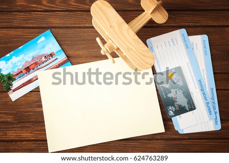 Blank notepad page, credit card and travel accessories on wooden background
