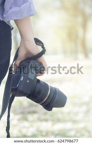 young woman photographer with camera in park