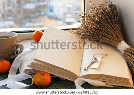 tangerines and vintage books on a marble table by the window in winter