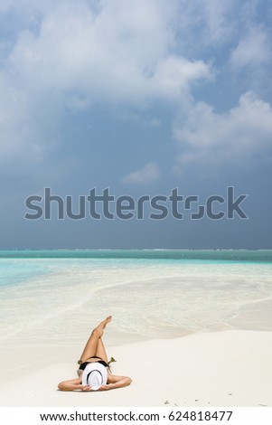 Woman lying on Maldivian sand beach