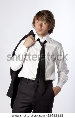 Portrait of a handsome model in business suit wearing his jacket on the shoulder. Studio shot. See more in my portfolio