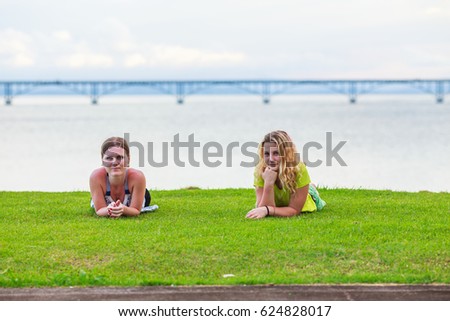 two girls lying on a green lawn in Samana, Dominican republic