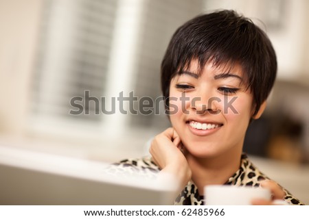 Pretty Smiling Multiethnic Woman Using Her Laptop Computer.