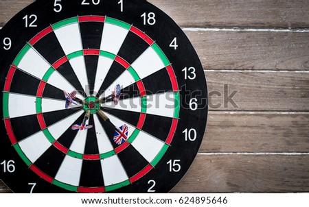 darts arrows in the target center (target, dart, board) dartboard over wood background