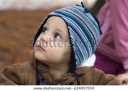 Little boy standing in autumn park
