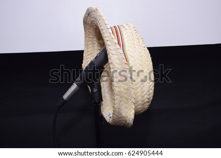 Straw hat hanging from a black microphone