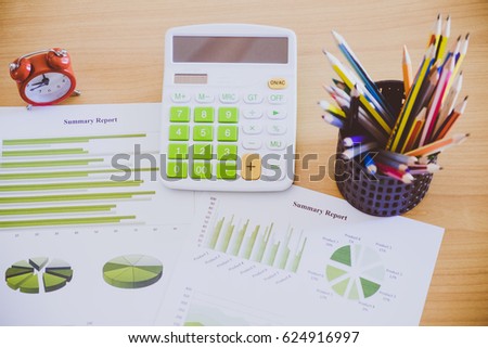 Many charts and graphs with many pencil, calculator, clock. Reflection light and flare. Concept image of data gathering and statistical working.
