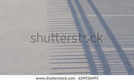 shadows of metal fences on the concrete floor