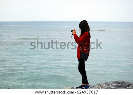 Young beautyful asian girl take a photo at Sunset beach Okinawa, Japan
