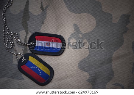 army blank, dog tag with flag of paraguay and venezuela on the khaki texture background. military concept