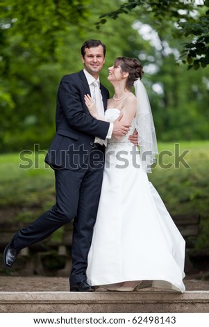 young wedding couple - freshly wed groom and bride posing outdoors on  their wedding day (color toned image)