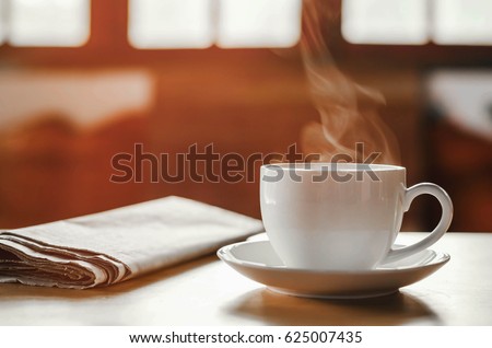 coffee cup with newspaper on the table, coffee shop background, warm tone