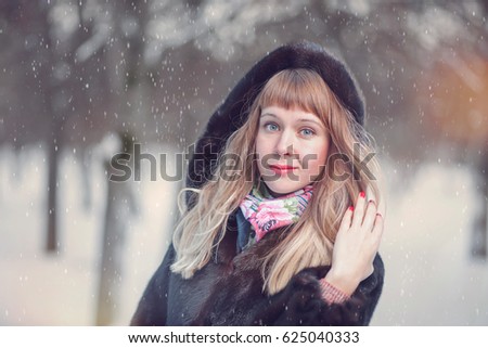 Vertical picture of a girl holding gifts in hands on street in winter